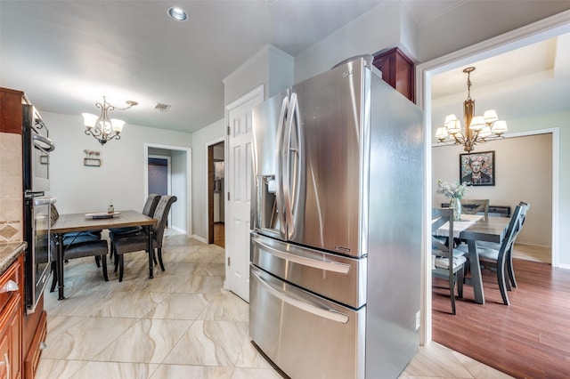 2307 Castle Rock Rd, Carrollton, TX 75007 - kitchen featuring stainless steel refrigerator with ice dispenser, a chandelier, decorative light fixtures, and baseboards