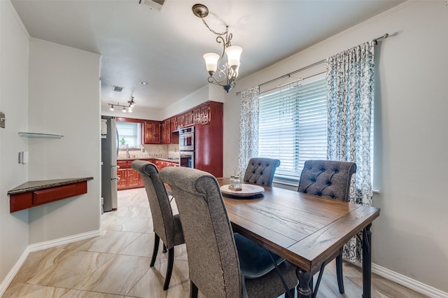 2307 Castle Rock Rd, Carrollton, TX 75007 - dining space featuring a chandelier, baseboards, and crown molding
