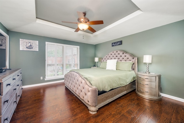 2307 Castle Rock Rd, Carrollton, TX 75007 - bedroom with a tray ceiling, baseboards, dark wood finished floors, and a ceiling fan
