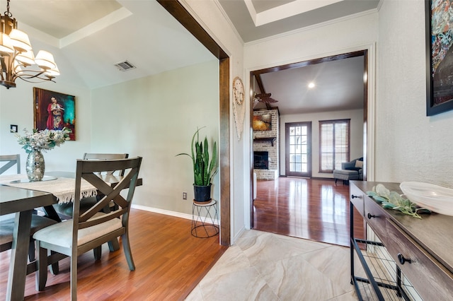 2307 Castle Rock Rd, Carrollton, TX 75007 - dining room featuring a chandelier, a fireplace, and wood finished floors