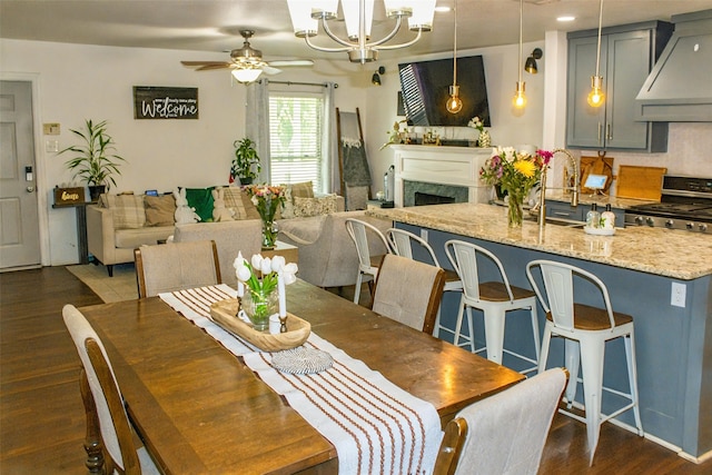 4024 Calmont Ave, Fort Worth, TX 76107 - dining space with a fireplace, dark wood finished floors, recessed lighting, and ceiling fan with notable chandelier