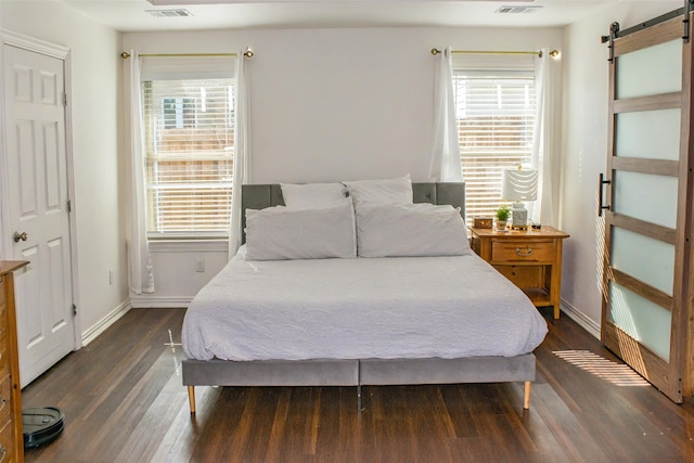 4024 Calmont Ave, Fort Worth, TX 76107 - bedroom with visible vents, baseboards, wood finished floors, and a barn door