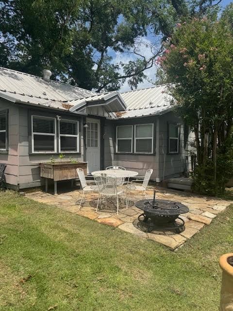 715 W Ball St, Weatherford, TX 76086 - rear view of property with an outdoor fire pit, a patio, a yard, and a metal roof