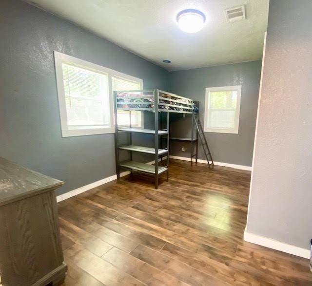 715 W Ball St, Weatherford, TX 76086 - bedroom with wood finished floors, baseboards, and a textured wall