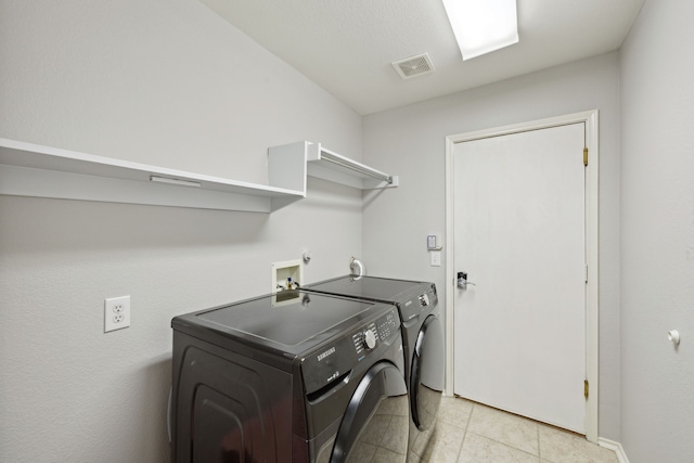 clothes washing area featuring laundry area, washer and dryer, baseboards, visible vents, and light tile patterned flooring