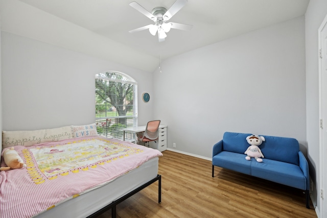 bedroom with baseboards, a ceiling fan, wood finished floors, and vaulted ceiling
