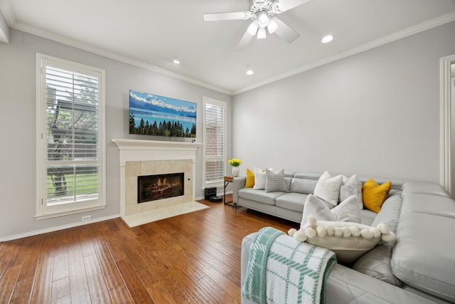 living room with a fireplace, a healthy amount of sunlight, ceiling fan, and wood-type flooring