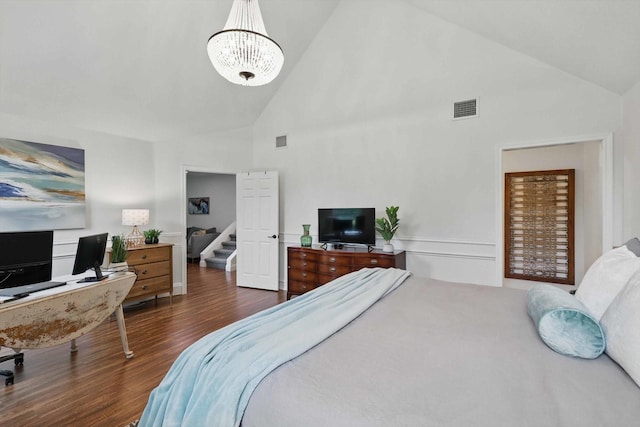bedroom featuring visible vents, wood finished floors, high vaulted ceiling, and an inviting chandelier