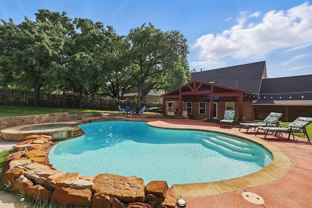view of swimming pool with a fenced backyard, a patio, and a pool with connected hot tub