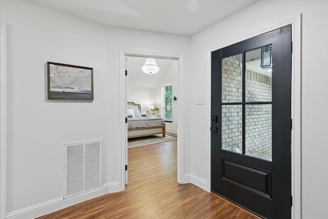 entryway featuring visible vents, baseboards, and wood finished floors