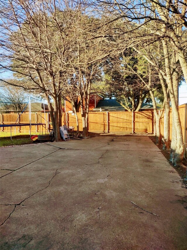 view of patio with a fenced backyard and a trampoline