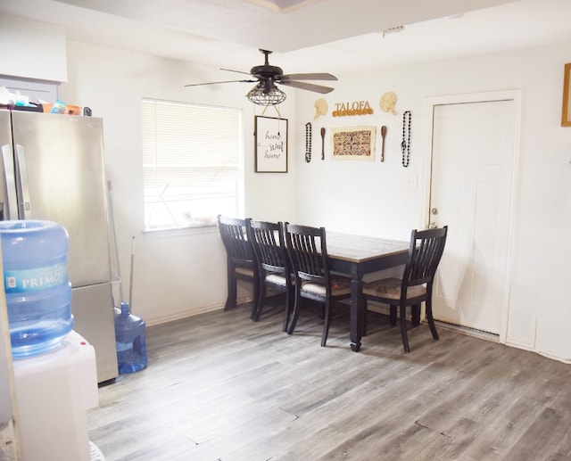dining room featuring light wood-type flooring, a ceiling fan, and baseboards