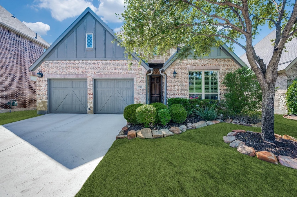 7924 Paisley, The Colony, TX 75056 - view of front of property with brick siding, driveway, board and batten siding, and a front yard