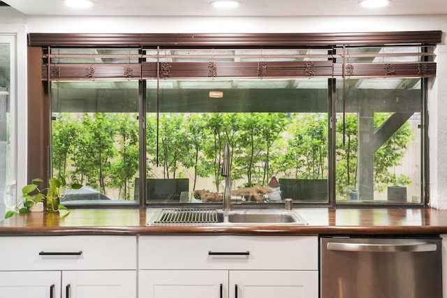 kitchen with white cabinets, dishwasher, and a sink