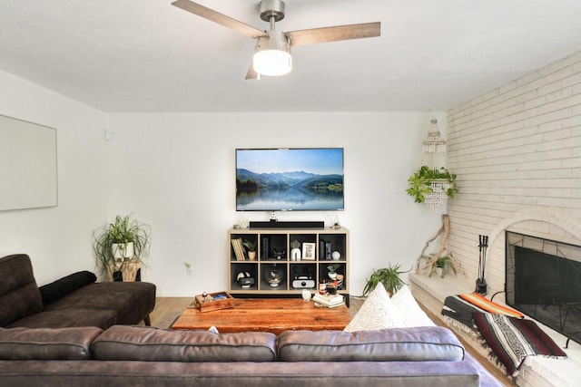 living room featuring a fireplace, wood finished floors, and a ceiling fan