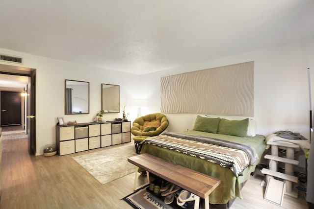 bedroom featuring wood finished floors and visible vents