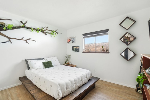bedroom featuring baseboards and wood finished floors