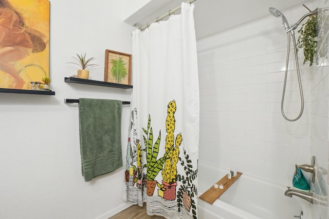 bathroom featuring baseboards and shower / bath combo