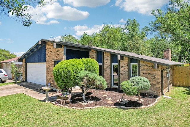 mid-century modern home with a chimney, brick siding, a front lawn, and an attached garage