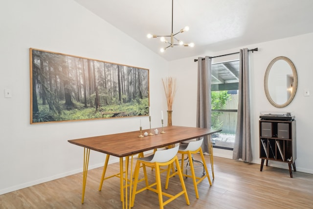 dining room with vaulted ceiling, wood finished floors, baseboards, and an inviting chandelier