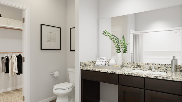 full bathroom with a spacious closet, toilet, vanity, and baseboards