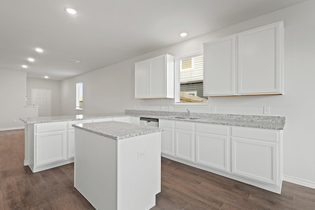 2433 Dahlia Dr, Fort Worth, TX 76123 - kitchen with a peninsula, a sink, recessed lighting, white cabinetry, and a kitchen island