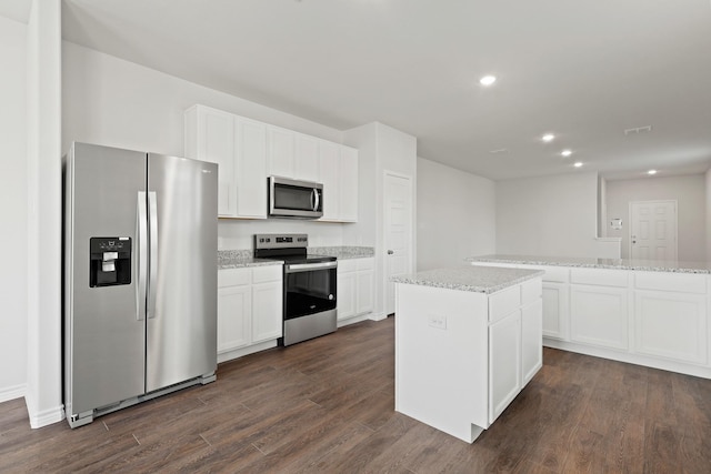 2433 Dahlia Dr, Fort Worth, TX 76123 - kitchen featuring appliances with stainless steel finishes, dark wood-type flooring, white cabinetry, a kitchen island, and recessed lighting