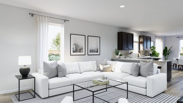 living area featuring light wood-style flooring, baseboards, and recessed lighting
