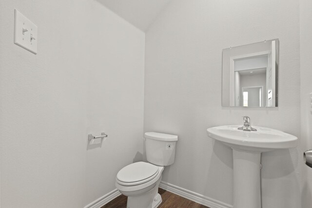 2433 Dahlia Dr, Fort Worth, TX 76123 - bathroom with wood finished floors, toilet, baseboards, a sink, and lofted ceiling