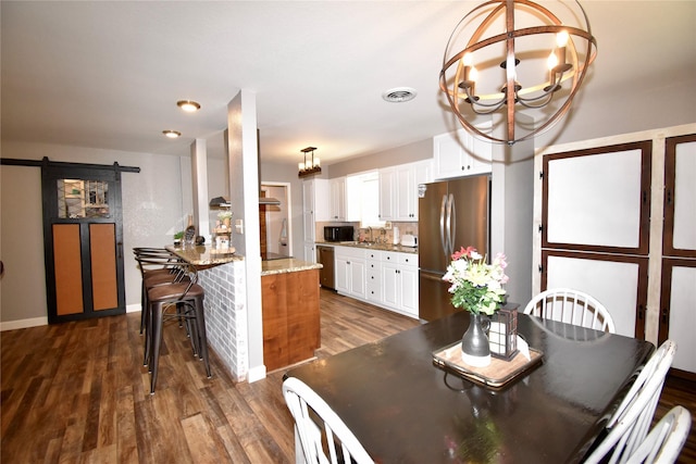 dining room featuring a barn door, baseboards, visible vents, a chandelier, and dark wood-type flooring