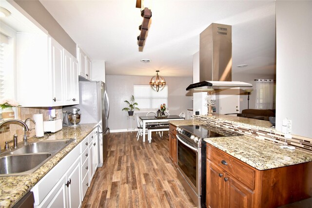 kitchen with tasteful backsplash, a sink, island range hood, stainless steel appliances, and white cabinets