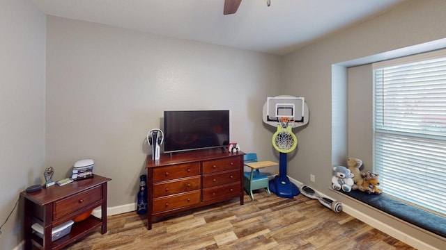 playroom with light wood-type flooring, baseboards, and ceiling fan