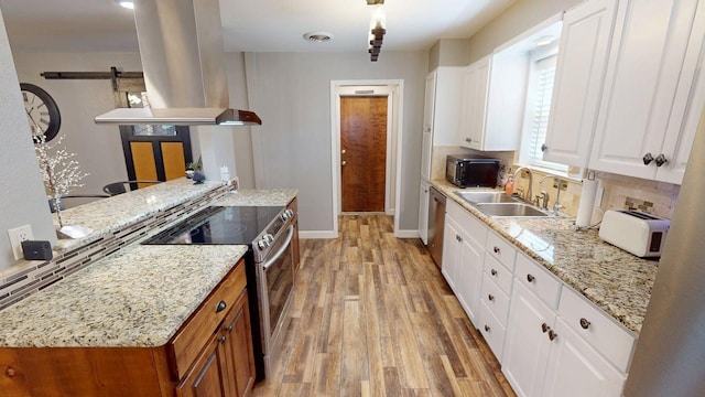 kitchen featuring a sink, island range hood, stainless steel appliances, light wood-style flooring, and white cabinetry