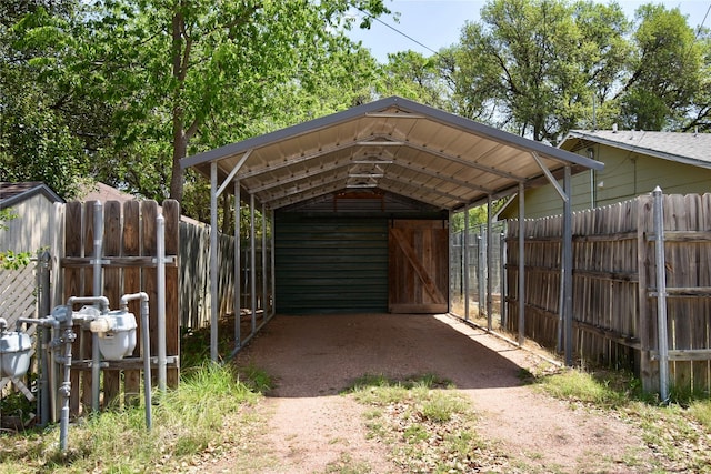view of parking featuring a detached carport and fence