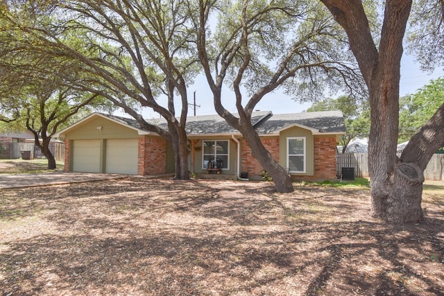 single story home with concrete driveway, a shingled roof, an attached garage, fence, and brick siding