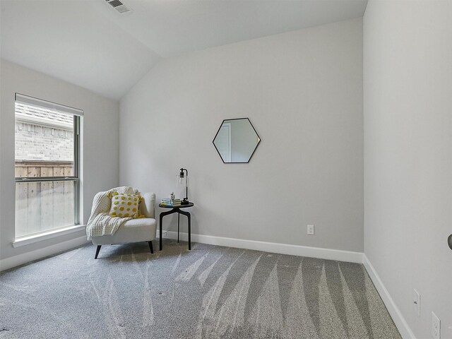 sitting room with vaulted ceiling, visible vents, carpet flooring, and baseboards