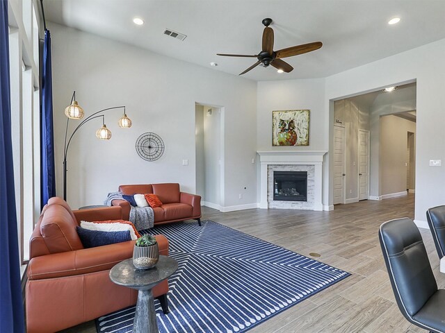 living room featuring visible vents, a glass covered fireplace, recessed lighting, a ceiling fan, and wood finished floors
