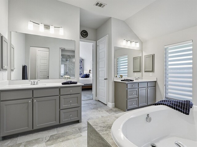 full bath featuring a bath, a sink, two vanities, ensuite bathroom, and visible vents
