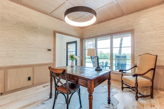 dining space with wallpapered walls, light wood-style flooring, wood walls, and a wainscoted wall