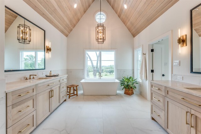 bathroom featuring a healthy amount of sunlight, a wainscoted wall, wooden ceiling, and a notable chandelier