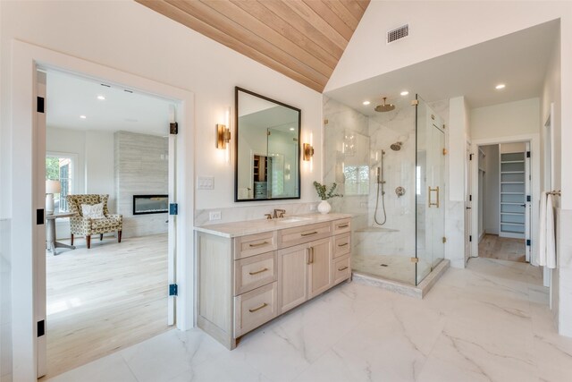 full bath with a marble finish shower, vaulted ceiling, visible vents, marble finish floor, and vanity