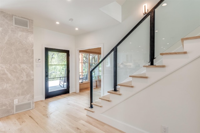 foyer with wood finished floors, visible vents, recessed lighting, and stairway