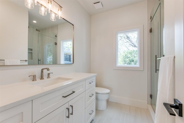 full bathroom with baseboards, vanity, a shower stall, and toilet