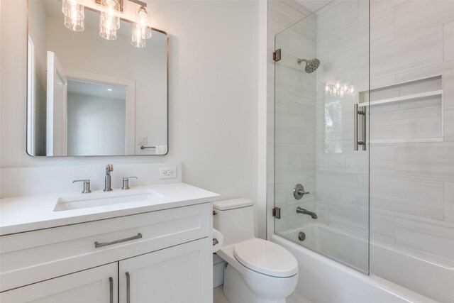 full bath featuring vanity, enclosed tub / shower combo, and toilet