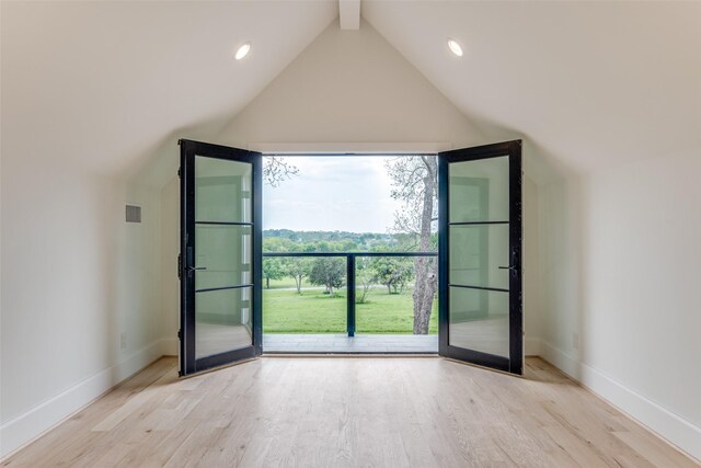 interior space with baseboards, wood finished floors, vaulted ceiling with beams, and visible vents