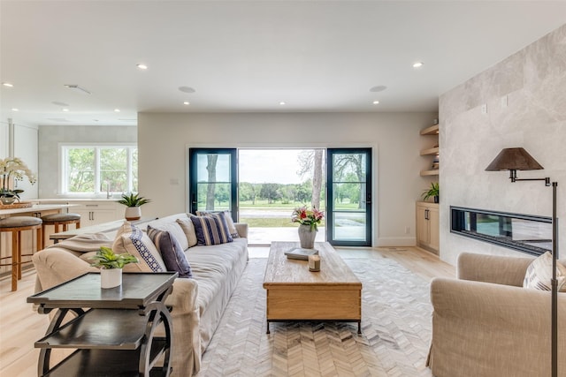 living area featuring light wood finished floors, a fireplace, and recessed lighting