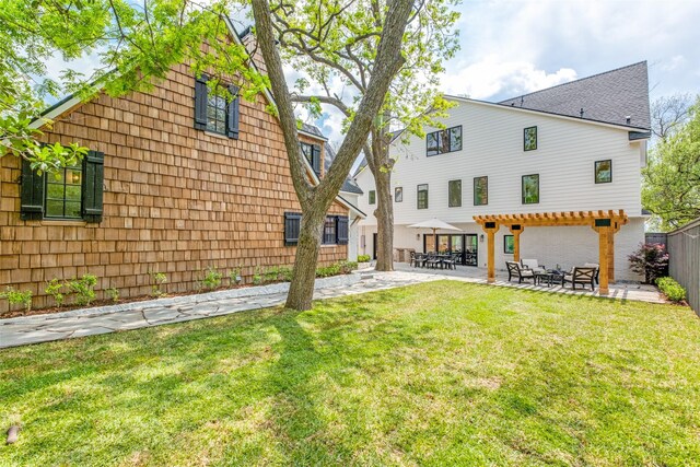 back of property with fence, a patio area, and a yard