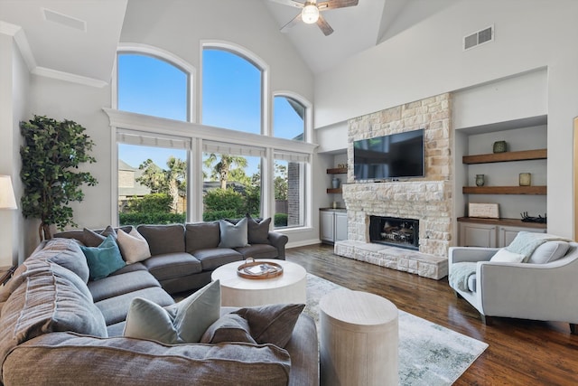 living room featuring visible vents, dark wood-style flooring, a fireplace, a ceiling fan, and high vaulted ceiling