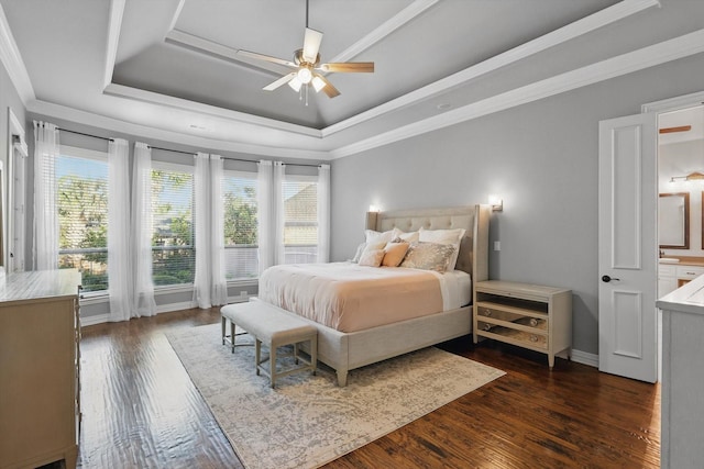 bedroom featuring baseboards, ornamental molding, dark wood-style flooring, and a tray ceiling