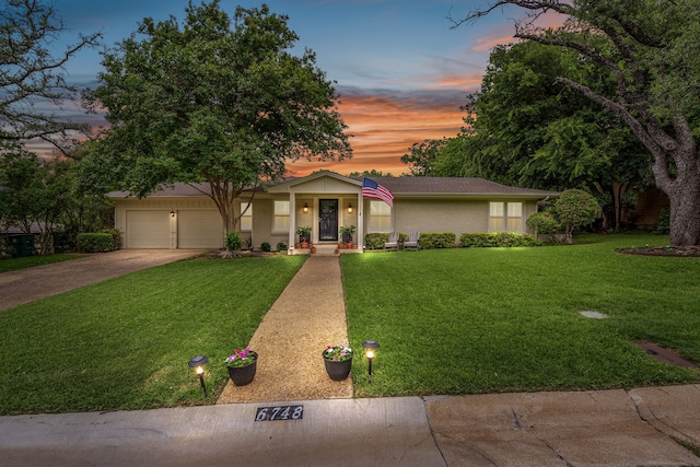 view of front facade featuring a garage, a yard, and concrete driveway